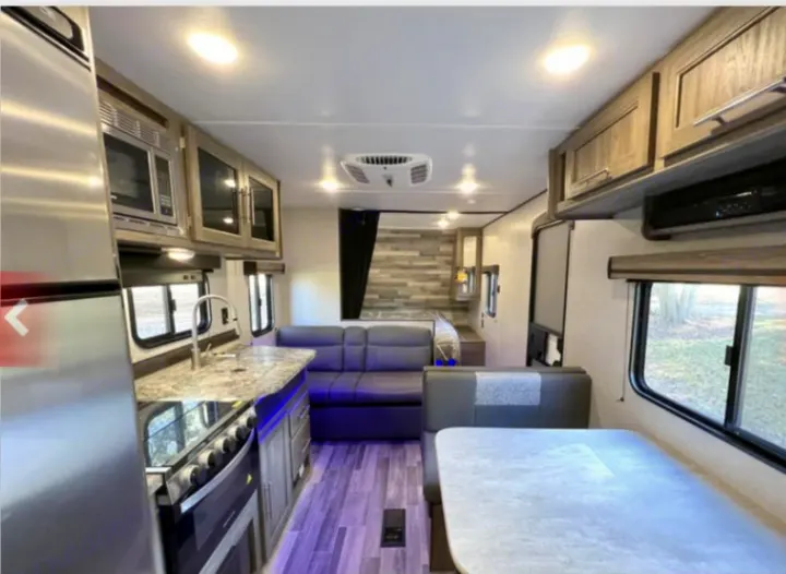 Explore this modern RV rental's spacious interior, featuring a full kitchen, living area, and dining booth.. Crossroads RV Zinger Lite 2022