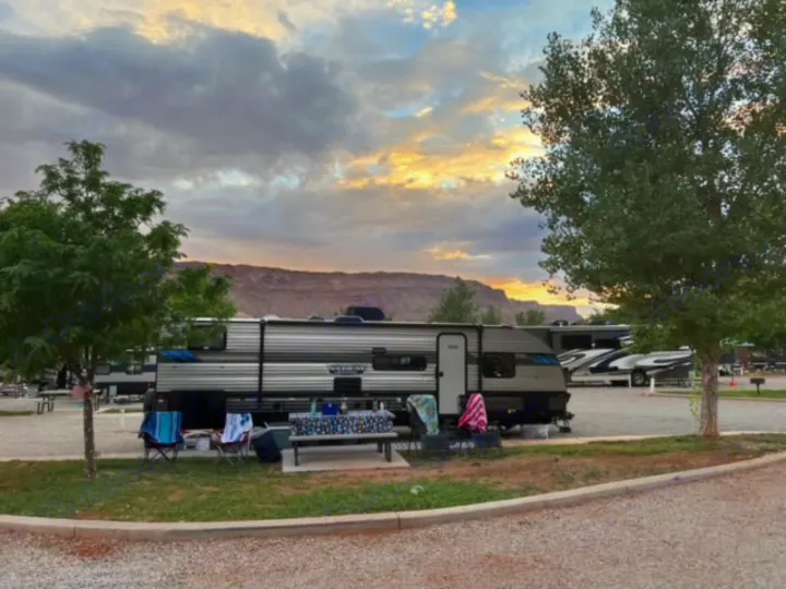 This RV rental is set up at a scenic campground under a cloudy sunset sky, with distant mountains.. Forest River Salem Cruise Lite 2022