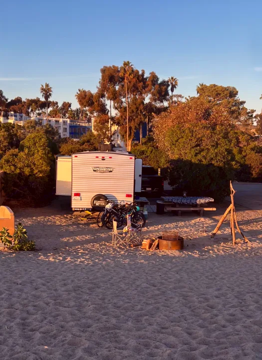 RV rental parked on a sandy beach campsite, equipped for a great adventure with bikes, picnic table, and fire pit.. Forest River Salem Cruise Lite 2022