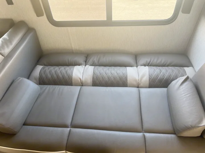 Modern gray sofa with comfortable seating and a stylish quilted bolster pillow, perfect for an RV rental adventure.. Forest River Salem Cruise Lite 2022