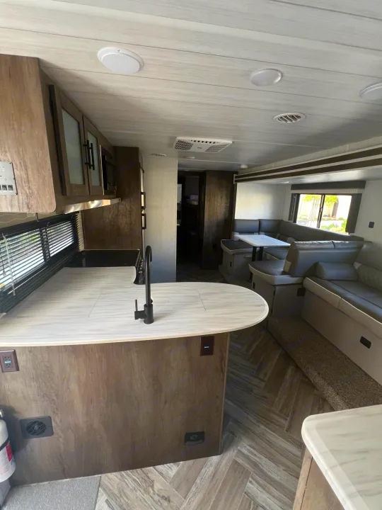 Modern RV rental interior with a bright kitchen, dining dinette, and comfortable living area. Perfect for travel adventures.. Forest River Salem Cruise Lite 2022