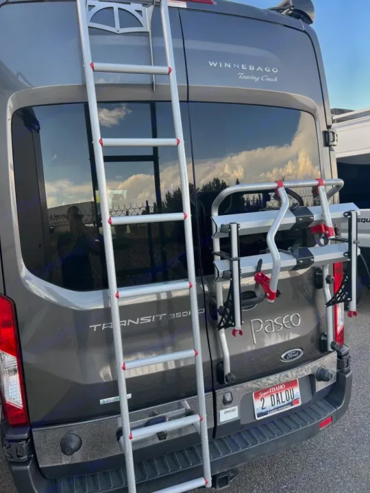 RV rental: Back of a grey Winnebago van with ladder, bike rack, and Idaho plate, ready for adventure.. Winnebago Paseo 2017