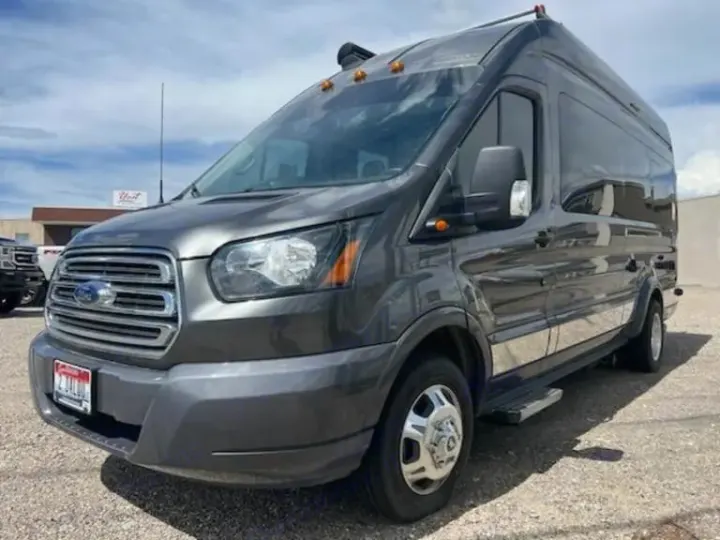 Dark gray Ford Transit camper van for RV rental, featuring a high roof and large side windows.. Winnebago Paseo 2017