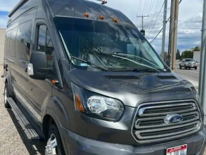Dark gray Ford Transit van, likely an RV rental, parked roadside. Ideal for travel and adventure.. Winnebago Paseo 2017