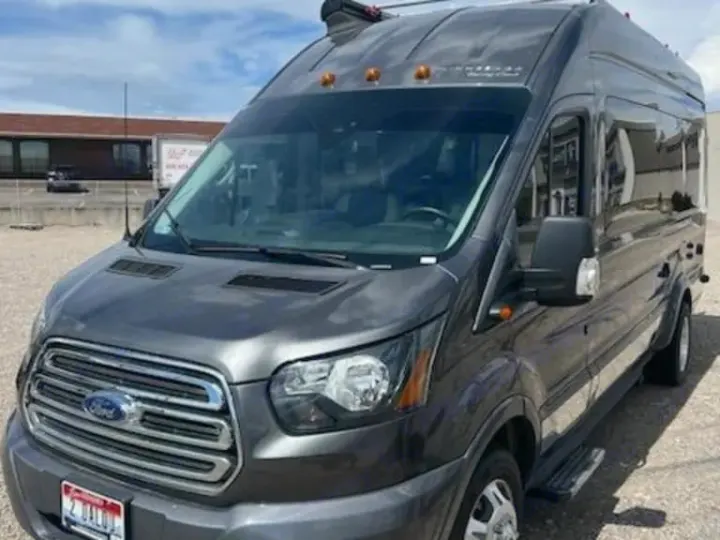 A sleek gray Ford Transit van RV rental, equipped as a modern camper van for adventures.. Winnebago Paseo 2017