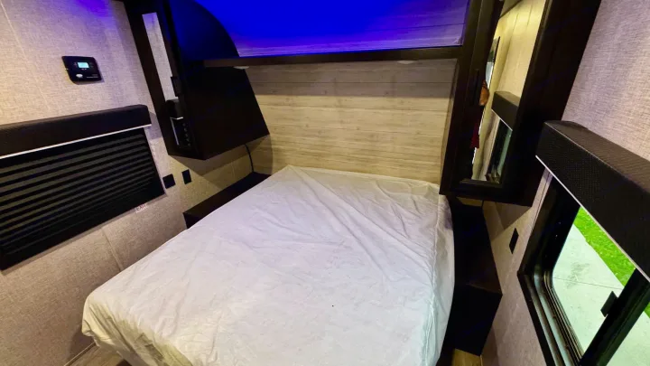 RV rental bedroom: a cozy space with a bed, electronic control panel, and ambient blue lighting.. Jayco Jay Flight SLX 2022