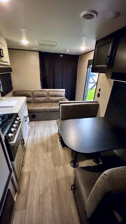 Spacious RV rental interior: kitchen, living area sofa, and dining booth with wood-look flooring.. Jayco Jay Flight SLX 2022