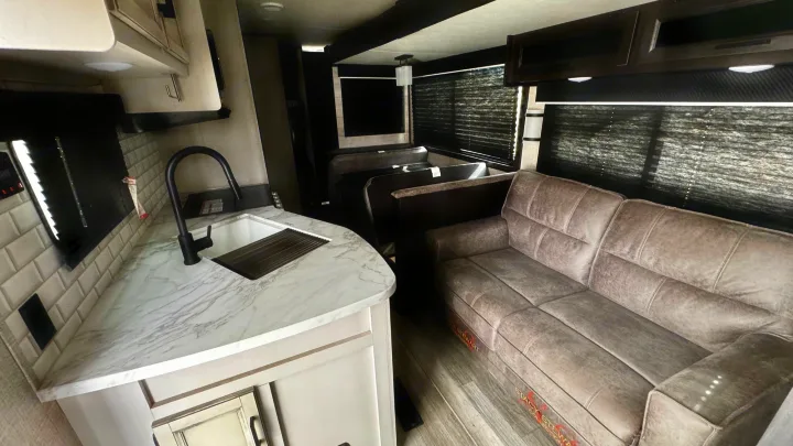 Bright RV rental interior featuring a modern kitchen, cozy dinette, and comfortable sofa. Your mobile home awaits.. Jayco Jay Flight SLX Rocky Mountain Edition 2022