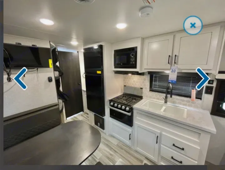 Inside an rv rental: compact kitchen with stove, microwave, sink, fridge, plus dinette and TV.. Jayco Jay flight 2024