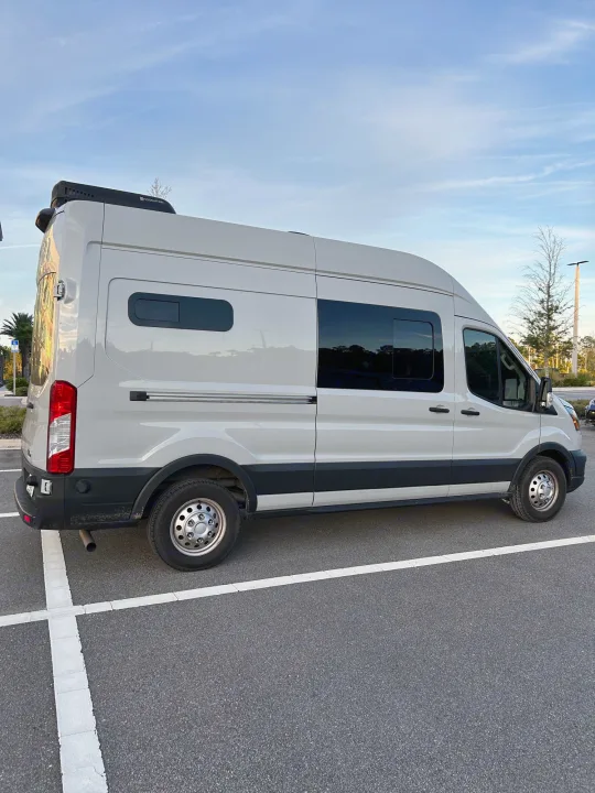 Light gray Ford Transit camper van with rooftop AC, perfect for an RV rental or road trip adventures.. Ford Transit 2023