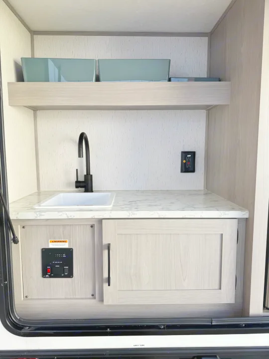 RV rental utility area: Features a modern sink, sleek countertop, and a control panel for tank levels/lights.. Dutchmen Other 2023