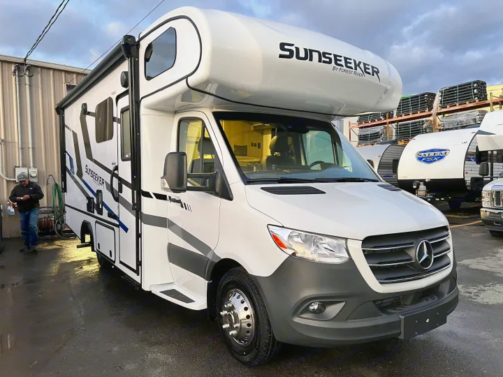 White Sunseeker by Forest River motorhome, ready for RV rental. This modern recreational vehicle features a prominent cab-over bunk.. Forest River Sunseeker 2024