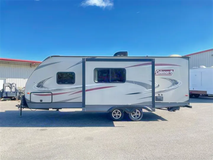 Gray Coleman travel trailer with a slide-out extended, shown from the side. Great option for your next RV rental.. Coleman 2305QB 2018