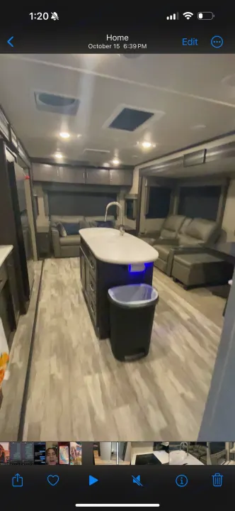 Spacious RV rental interior with a modern kitchen island, bright lighting, and a comfortable living area.. Grand Design Reflection 2022