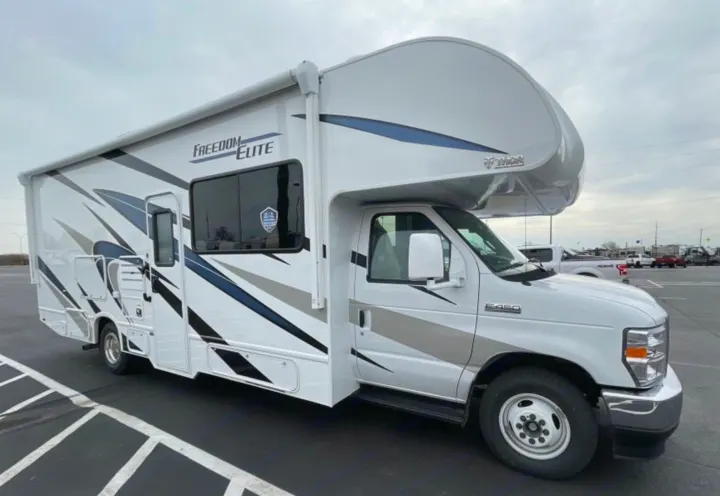 White Thor Freedom Elite Class C RV rental, parked outdoors.. Thor Freedom Elite 2023