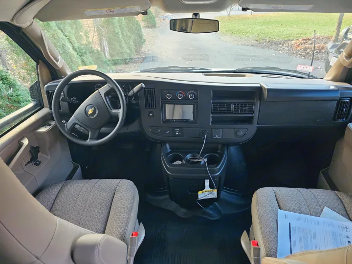 Front cabin view of an RV rental van, showing the dashboard, steering wheel, driver/passenger seats, and clear windshield.. Other Other 2024