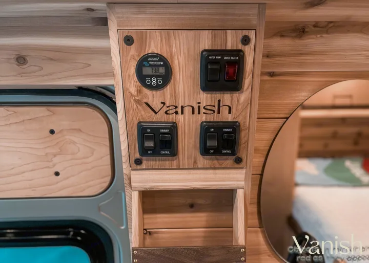 RV rental wood-paneled control panel: Victron battery monitor (79.8%), water pump, heater, and light switches.. Ram Promaster 2022