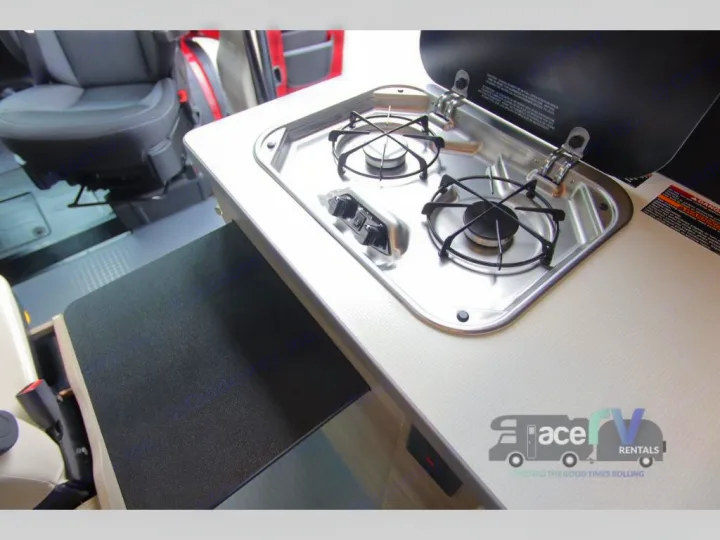 RV rental interior: compact kitchen with a 2-burner stove, pull-out counter extension, perfect for on-the-go meals.. Winnebago Solis 2021
