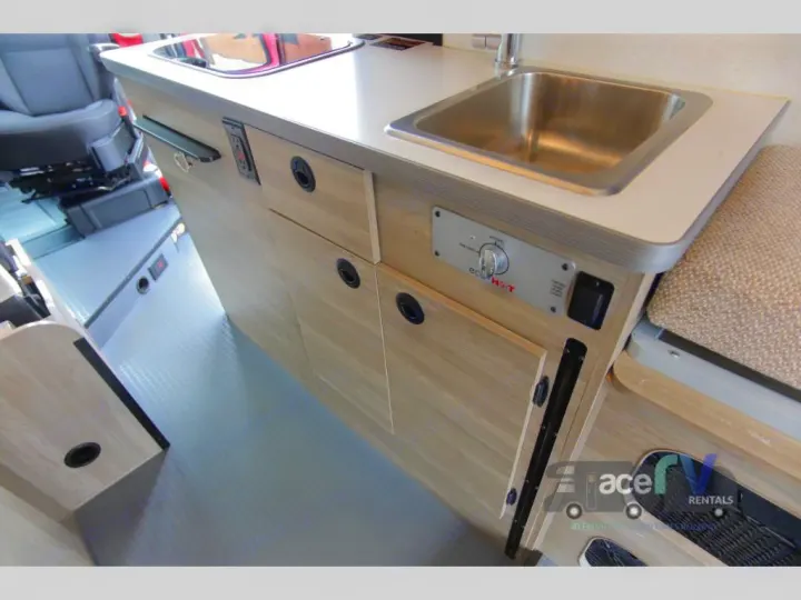 This rv rental offers a compact kitchenette area, complete with a stainless steel sink, countertop, and storage cabinets.. Winnebago Solis 2021