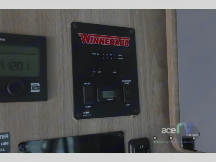 Winnebago RV rental: Essential control panel displaying generator hours, water, tank levels, and battery status for your journey.. Winnebago Solis 2021
