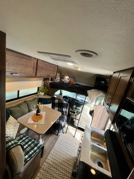 This RV rental offers a view into its comfortable living space: a dining area, kitchen, and cozy overhead bed.. Winnebago Minnie Winnie 2022