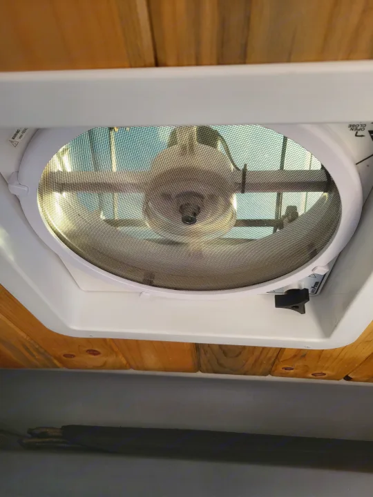 **RV rental** ceiling fan/vent providing fresh air inside, with a view through its mesh screen.. Dodge Ram Promaster 2021