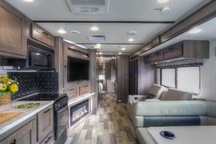 Explore this RV rental's sleek interior, featuring a full kitchen, living room, modern fireplace, and dining area.. FR3 FR3 Motorhome 2022