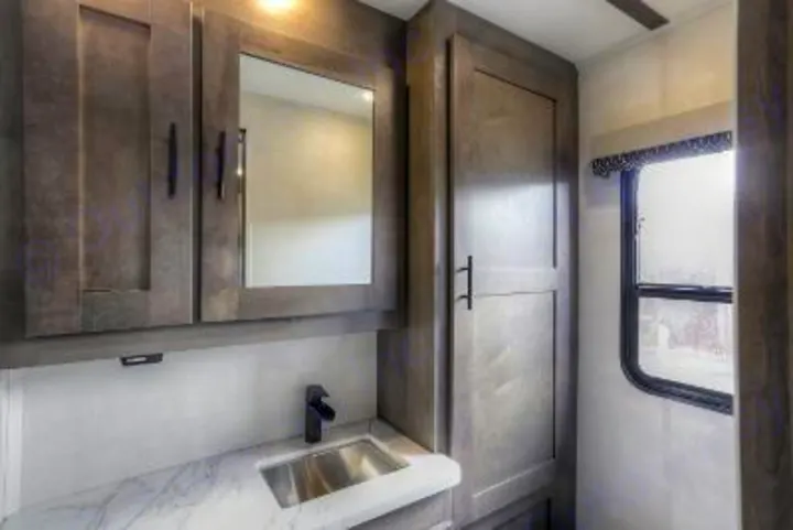 Modern RV rental bathroom featuring a vanity with sink, medicine cabinet, and ample storage, plus a window.. FR3 FR3 Motorhome 2022
