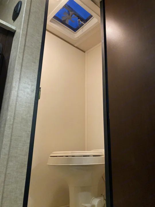 RV rental: Compact bathroom interior with a white toilet and ceiling vent open to the blue sky.. Forest River Cherokee Wolf Pack Toy Hauler 2017