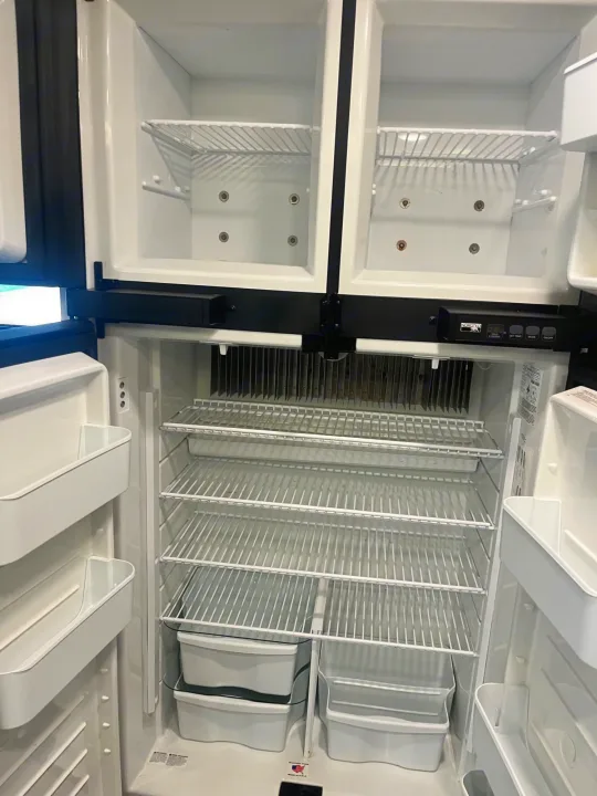 Empty, clean RV rental refrigerator with spacious freezer and fridge sections, ready for your road trip.. Entegra Vision 2023