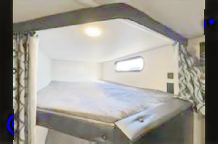 Upper bunk bed in an rv rental, featuring a mattress, window, and privacy curtains. Ideal for camping trips!. Forest River Cherokee 2022