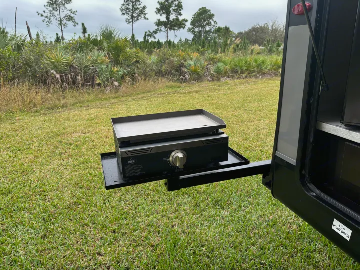 This rv rental features a convenient outdoor griddle setup on a pull-out shelf, ideal for camping meals.. Jayco Jay Flight 2023