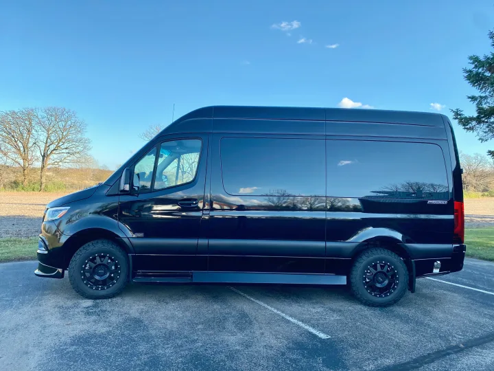 Sleek black Mercedes-Benz Sprinter van, customized for adventure and potentially an rv rental, parked outdoors on asphalt.. Mercedes Benz Sprinter 2500 2024
