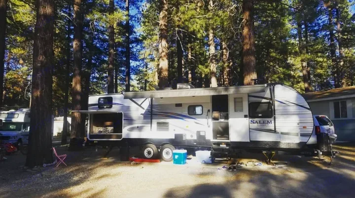 Spacious Salem RV rental at a sunny, tree-filled campsite. Ideal for outdoor adventures.. Forest River Salem 2019