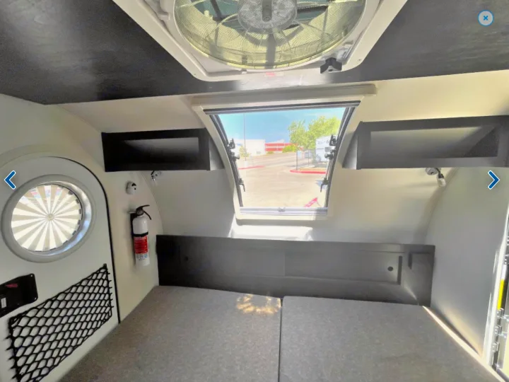 Experience an RV rental! Interior with comfortable bed, open rear window, ceiling fan, and storage. Ready for adventure.. T@G XL Boondocks 2023