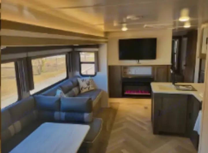 RV rental: Bright interior, large windows, dinette, modern fireplace, and kitchen island.. Forest River Wildwood 2022