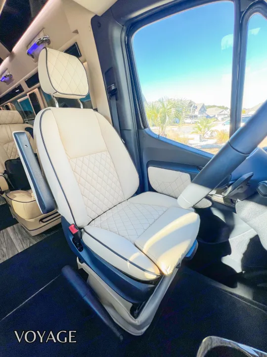 Luxury RV rental: Plush, quilted cream captain's seat with a clear view of palm trees & homes.. Mercedes-Benz Sprinter 419 LWB High Roof 2024