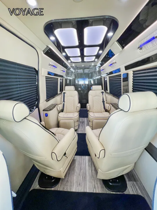 Spacious custom RV rental interior with cream leather captain chairs, wood-look flooring, and ambient lighting.. Mercedes-Benz Sprinter 419 LWB High Roof 2024