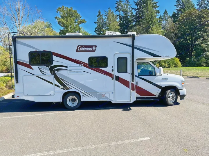 A white Coleman RV rental parked outdoors, ready for travel. Ideal for a road trip adventure.. Coleman 22EQ 2022