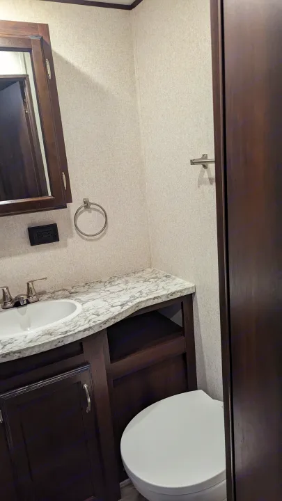 RV rental's compact bathroom features a vanity, sink, mirror, toilet, towel ring, and outlet.. Jayco Jay Flight 2018