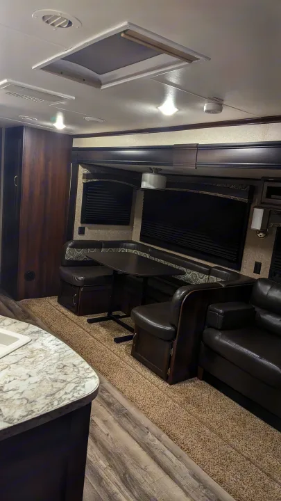 RV rental: a cozy living area with a U-shaped dinette, sofa, and a bright, functional kitchen counter on the left.. Jayco Jay Flight 2018