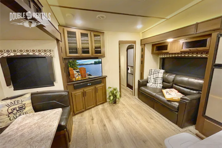 Experience this rv rental's spacious living area: comfortable seating, TV, and dining table.. Prime Time Crusader Lite 2020