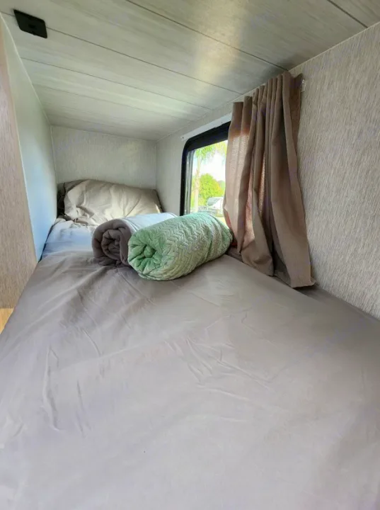 Cozy RV rental bunk bed with soft bedding & window view. Perfect for travel comfort.. Other Other 2024