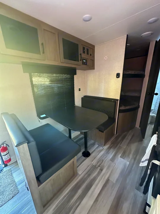 This rv rental features a cozy interior with a dinette, overhead cabinets, and bunk beds, perfect for family travel.. Other Other 2024