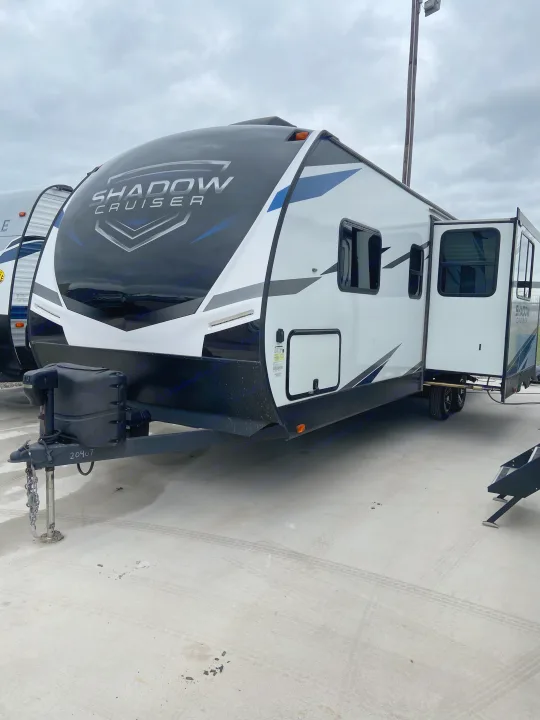 Front view of a white and black Shadow Cruiser travel trailer, ideal for RV rental, with an extended slide-out.. Cruiser RV Shadow Cruiser 2022