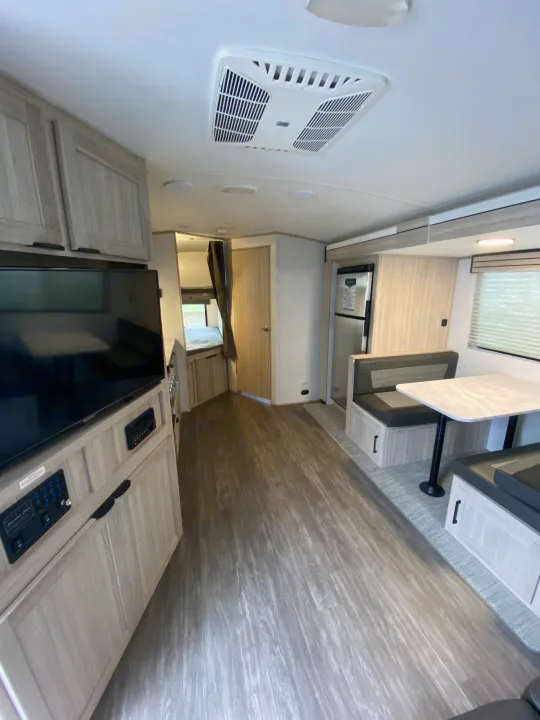 Step inside this inviting rv rental. Features include a dining booth, fridge, TV, bunks, and light wood interior.. Cruiser RV Shadow Cruiser 2022