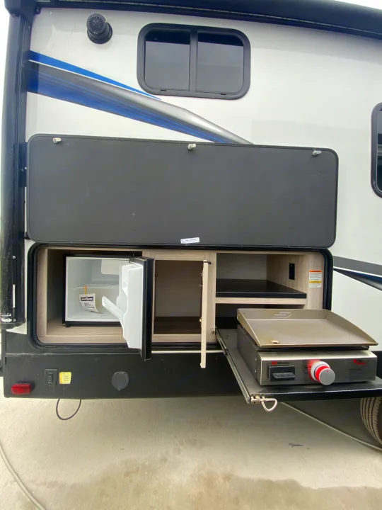 This RV rental features a convenient outdoor kitchen with a mini-fridge, cabinet storage, and a pull-out griddle.. Cruiser RV Shadow Cruiser 2022