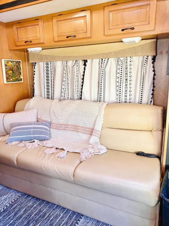 RV rental interior: A light sofa with pillows & throw, geometric curtains, and wood cabinets creates a cozy, inviting space.. Forest River Coachmen Prism 2014