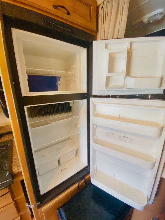 This clean, open RV rental refrigerator and freezer is ready for your next adventure, showing ample space for food storage.. Forest River Coachmen Prism 2014