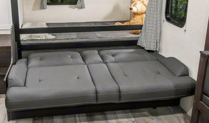 RV rental: Bunk beds above a gray convertible sofa, offering versatile sleeping in a compact interior.. Sportsmen SE 2023